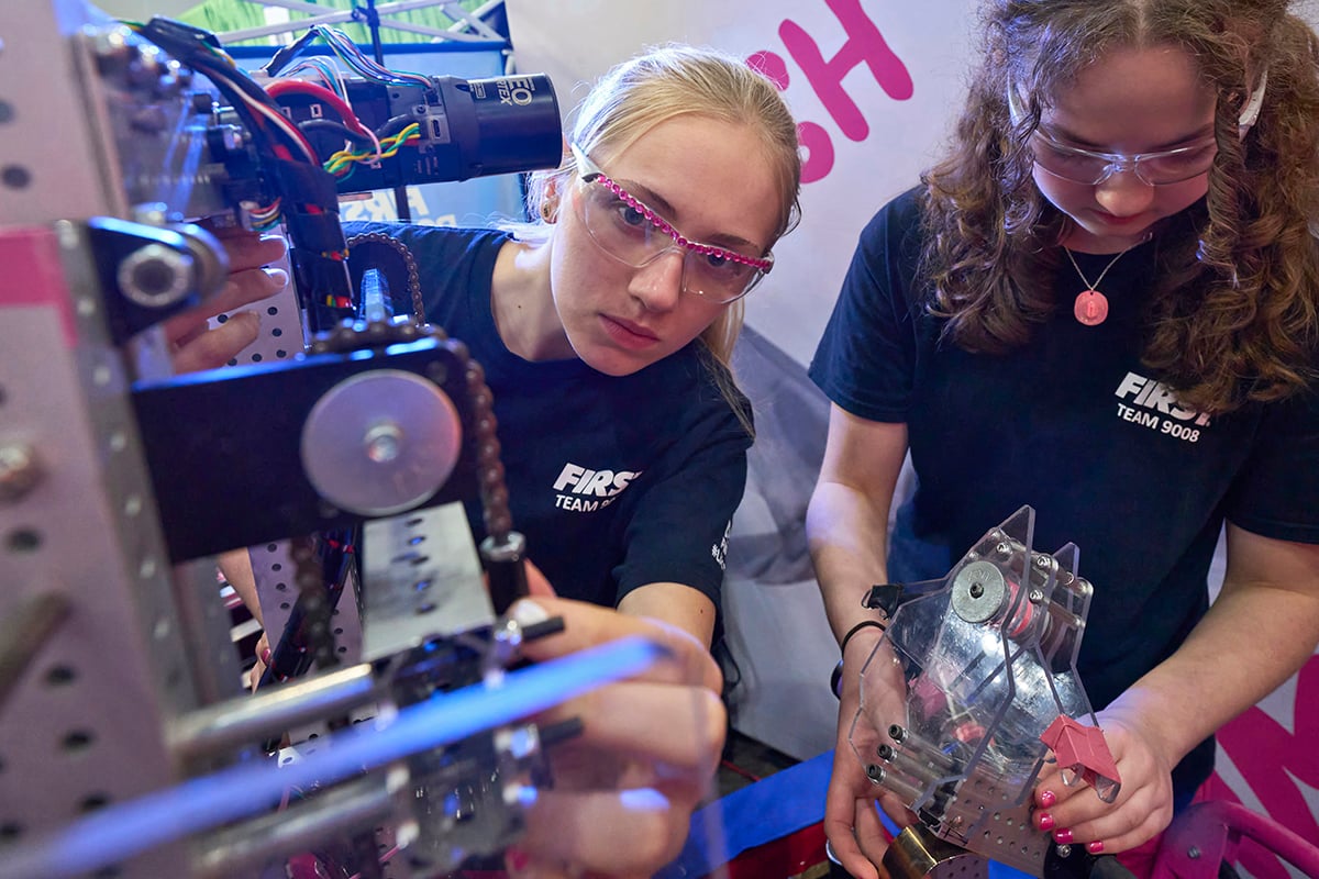 Two FIRST Robotics Competition students working on their robot at FIRST Championship