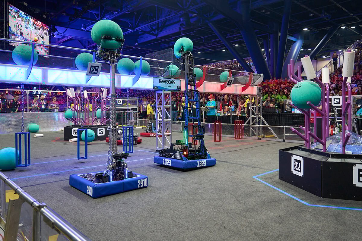 FIRST Robotics Competition robots scoring game objects at FIRST Championship